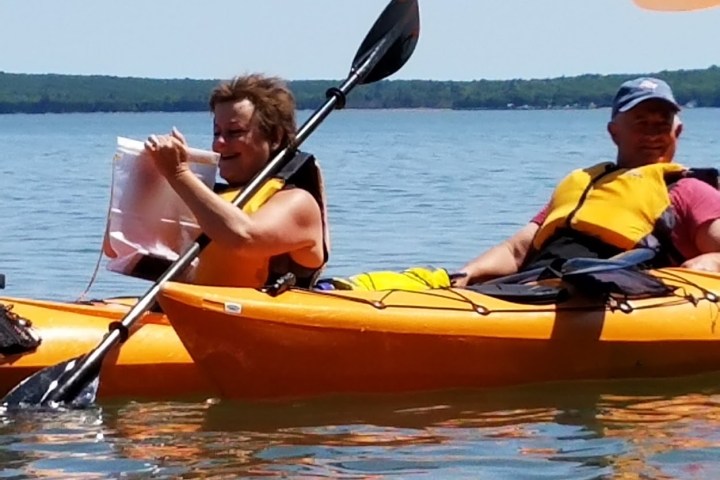A close up of people smiling in Kayaks