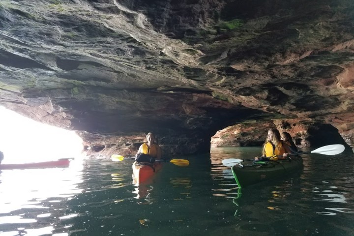 A group of people kayaking in caves at Sand Island