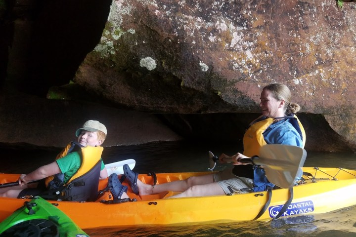 A boy and a woman kayaking in a cave