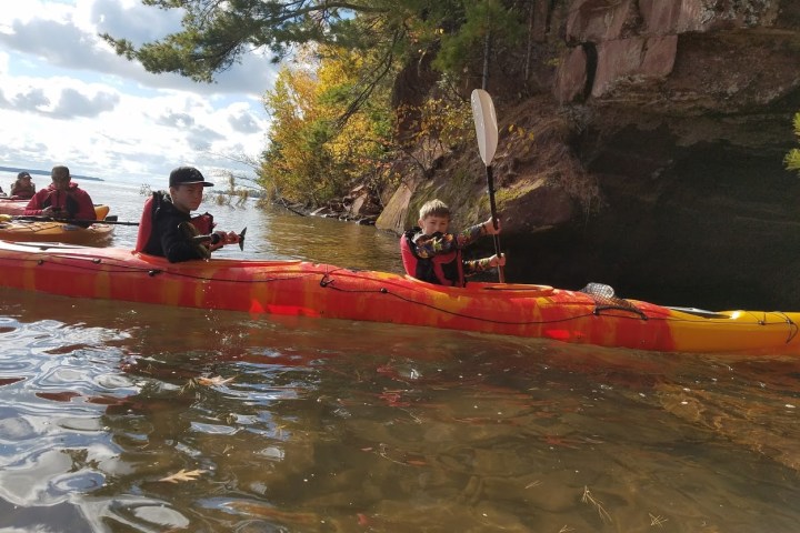 Two boys paddling in kayaks