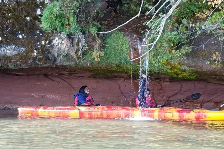 Kayaking under a waterfall at red cliff caves