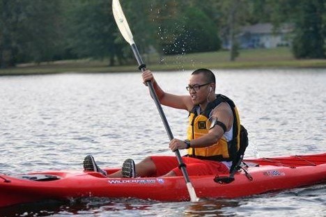 a man riding on the back of a boat in a body of water